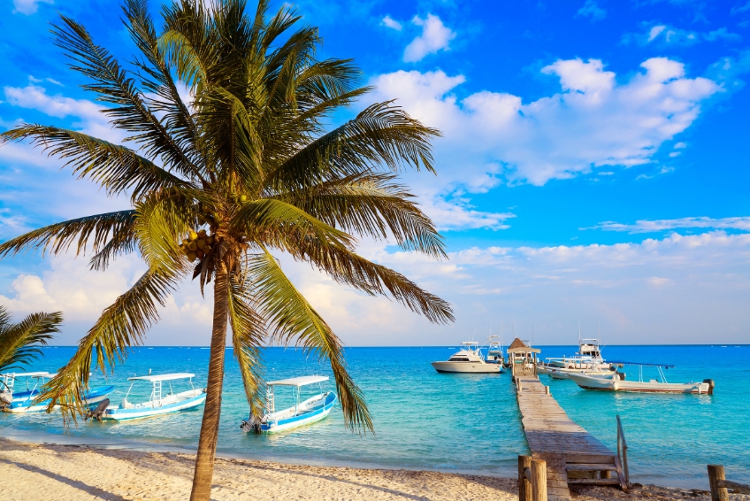 Dock and boats on turquoise waters in Puerto Morelos