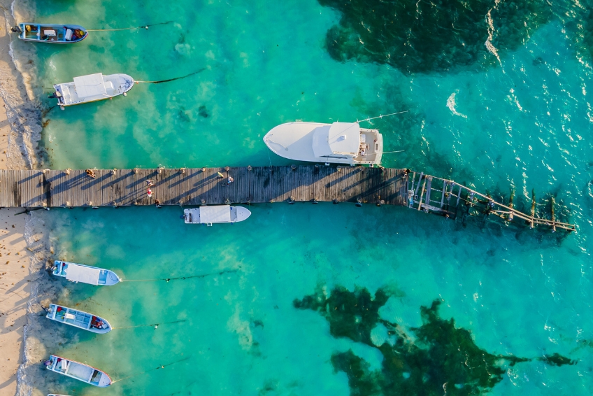 Dock and boats on turquoise waters in Puerto Morelos