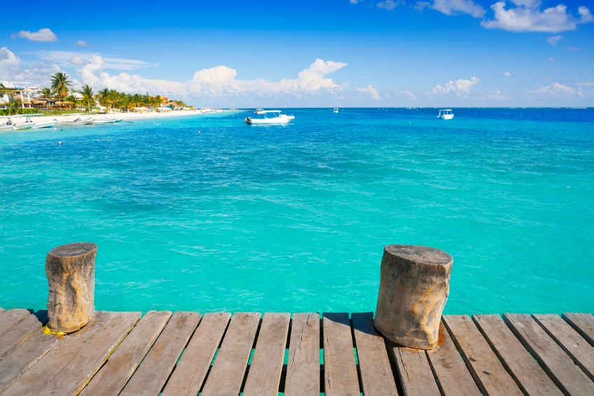Dock and boats on turquoise waters in Puerto Morelos